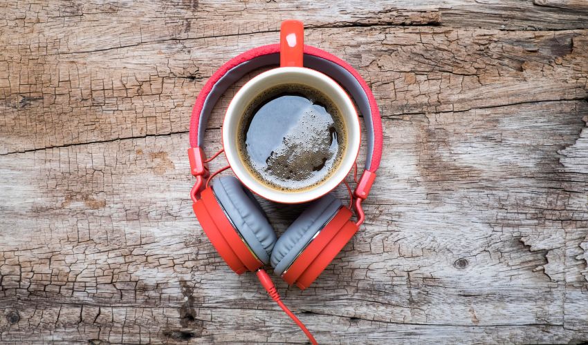 Cuffie e tazza di caffè, a richiamare la Playlist estiva ideale per la tua pausa caffè.