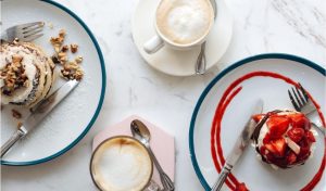 Colazione con capsule: varietà di bevande calde accanto a dolci e pancake